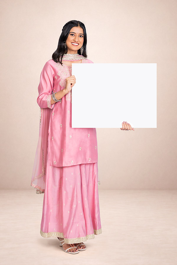 Indian woman holding a blank white signboard in traditional pink attire