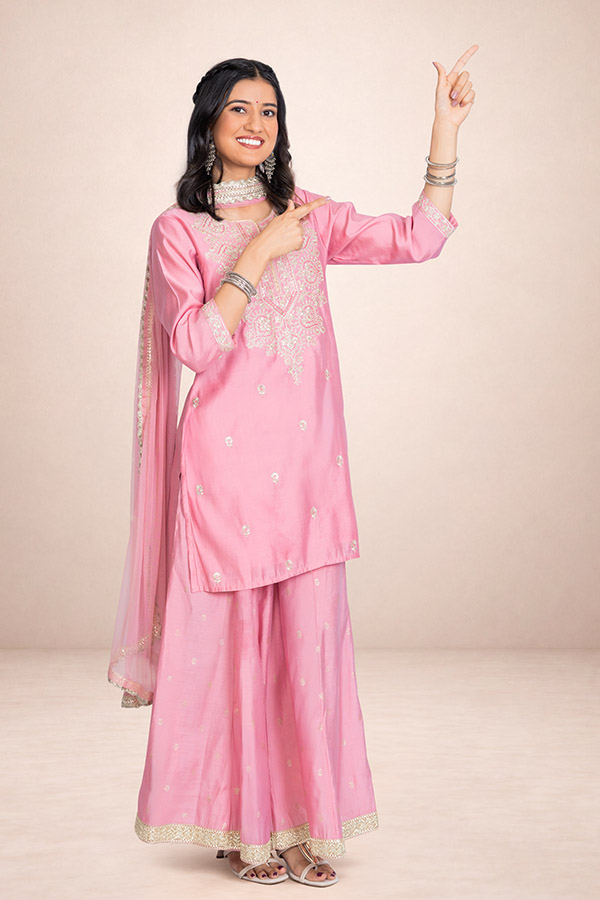 Indian woman pointing upwards in a pink traditional outfit