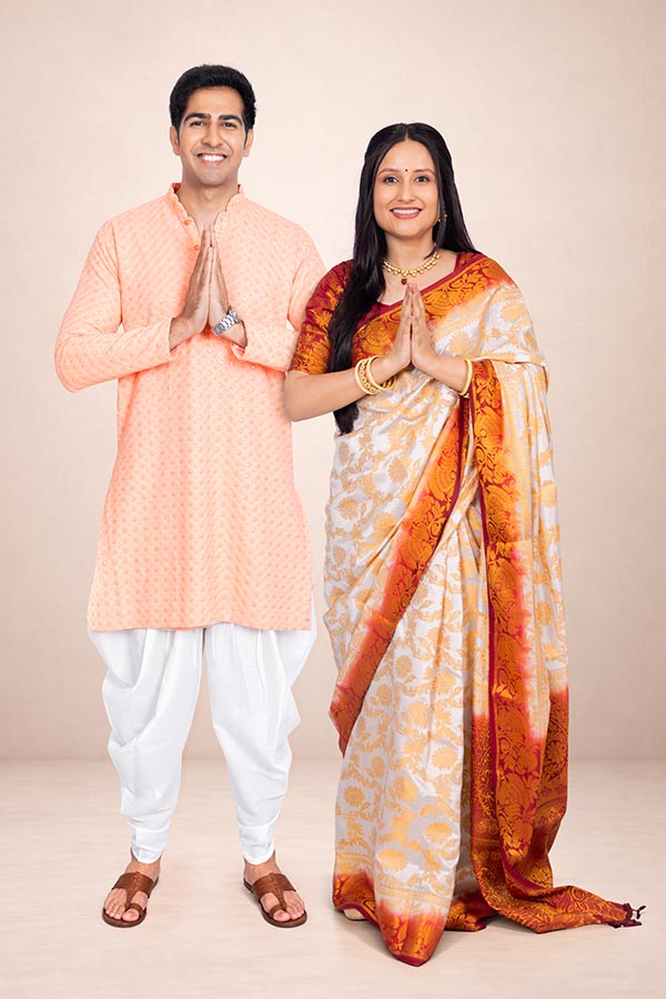 Indian couple greeting with folded hands in traditional festive attire